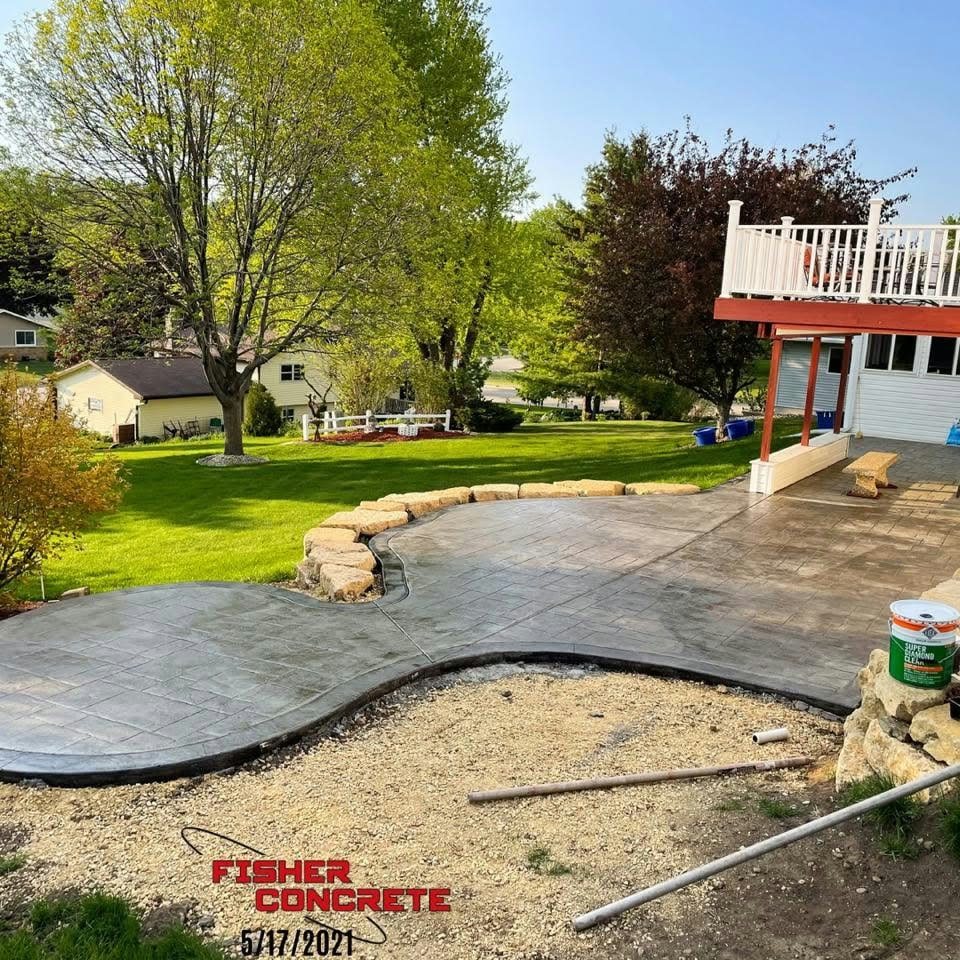 Stamped concrete patio with curved edges in a backyard