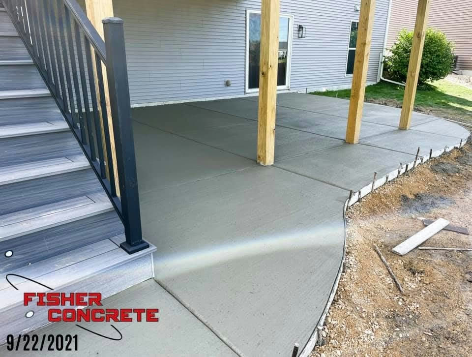 Concrete patio poured under a deck with curved edge