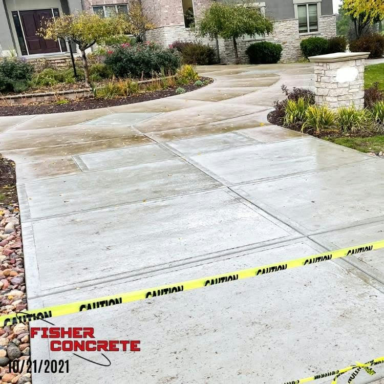 Finished driveway and walkway at a stone-front home