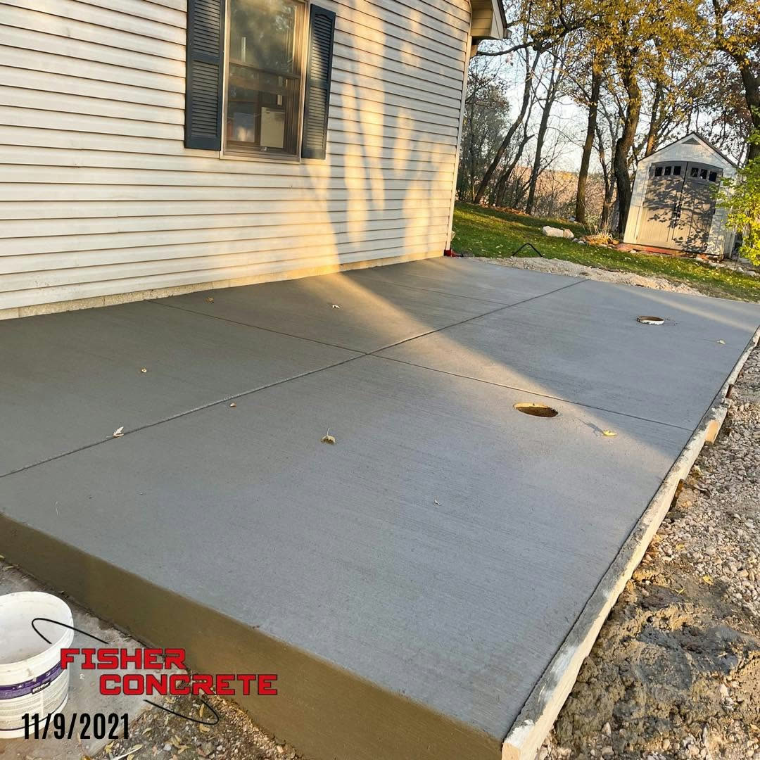 Broom-finished concrete patio slab beside a house