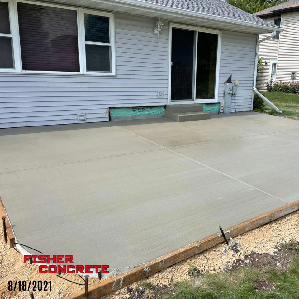 Large broom-finished backyard patio at a ranch home