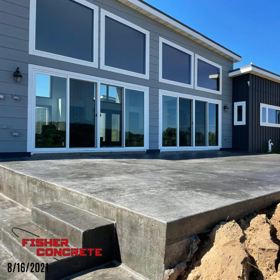 Raised concrete patio and steps at a modern window wall