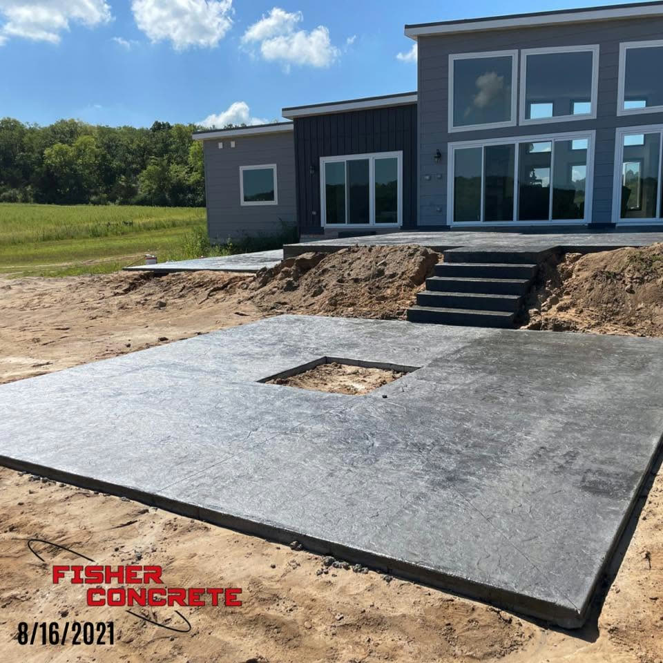Stamped concrete patio with fire pit opening at a new build