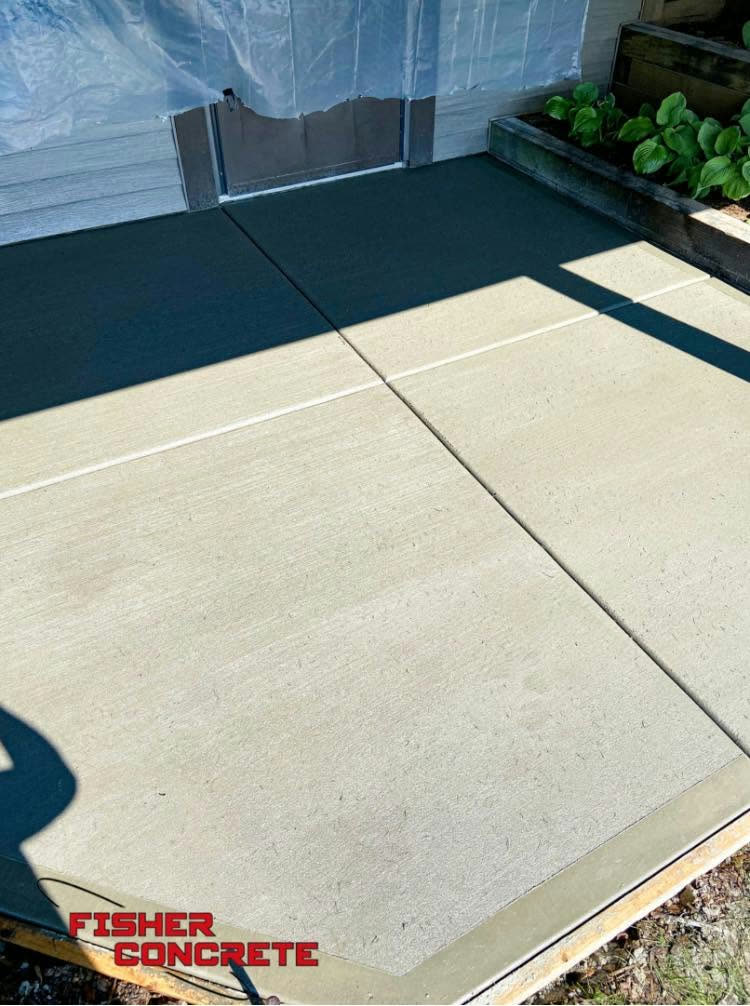 Small broom-finished slab poured beside a raised garden bed