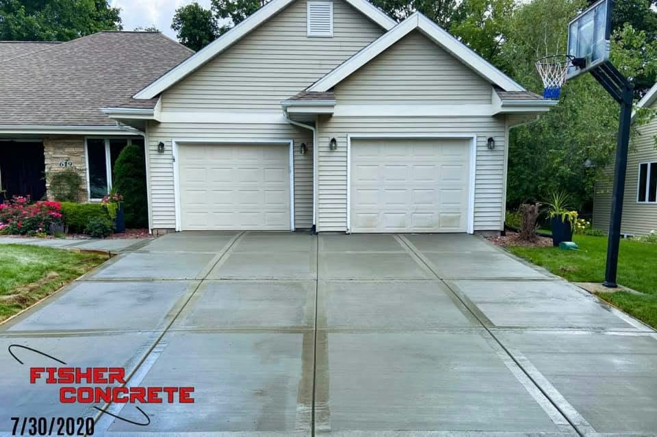 Wide two-car driveway with ribbon banding and basketball hoop