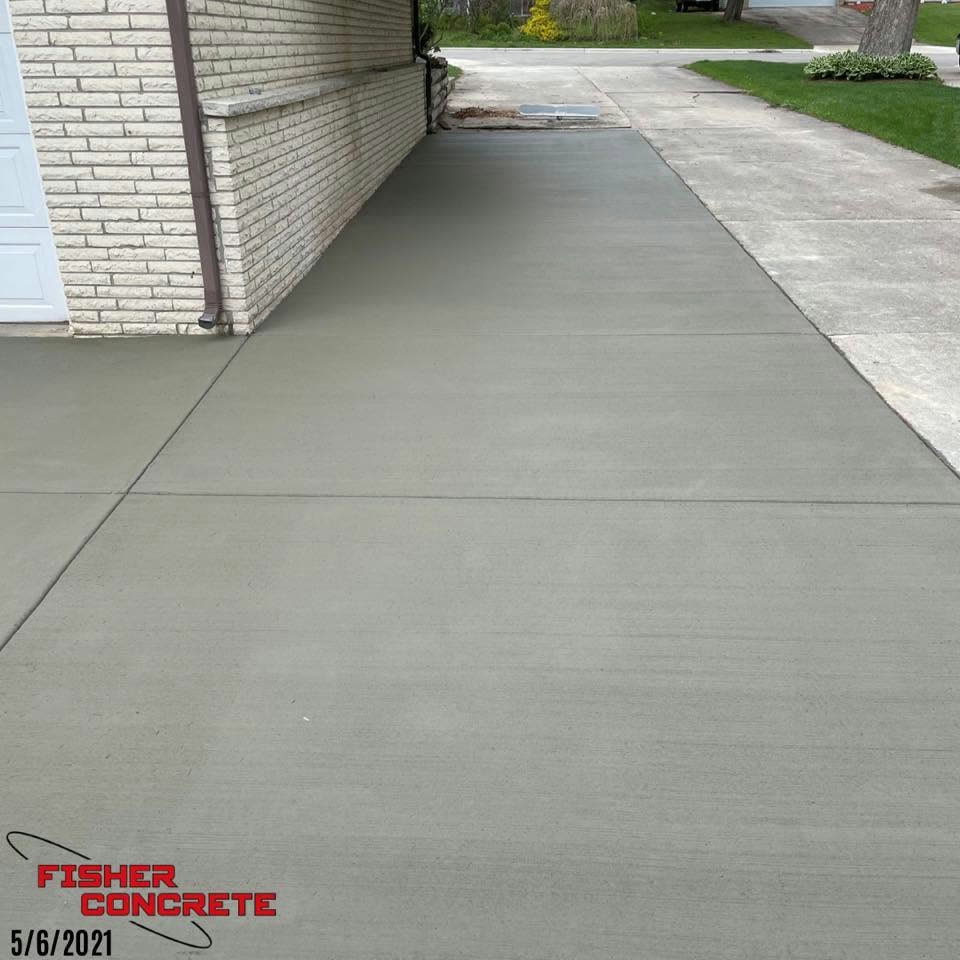 Broom-finished side driveway along a brick home
