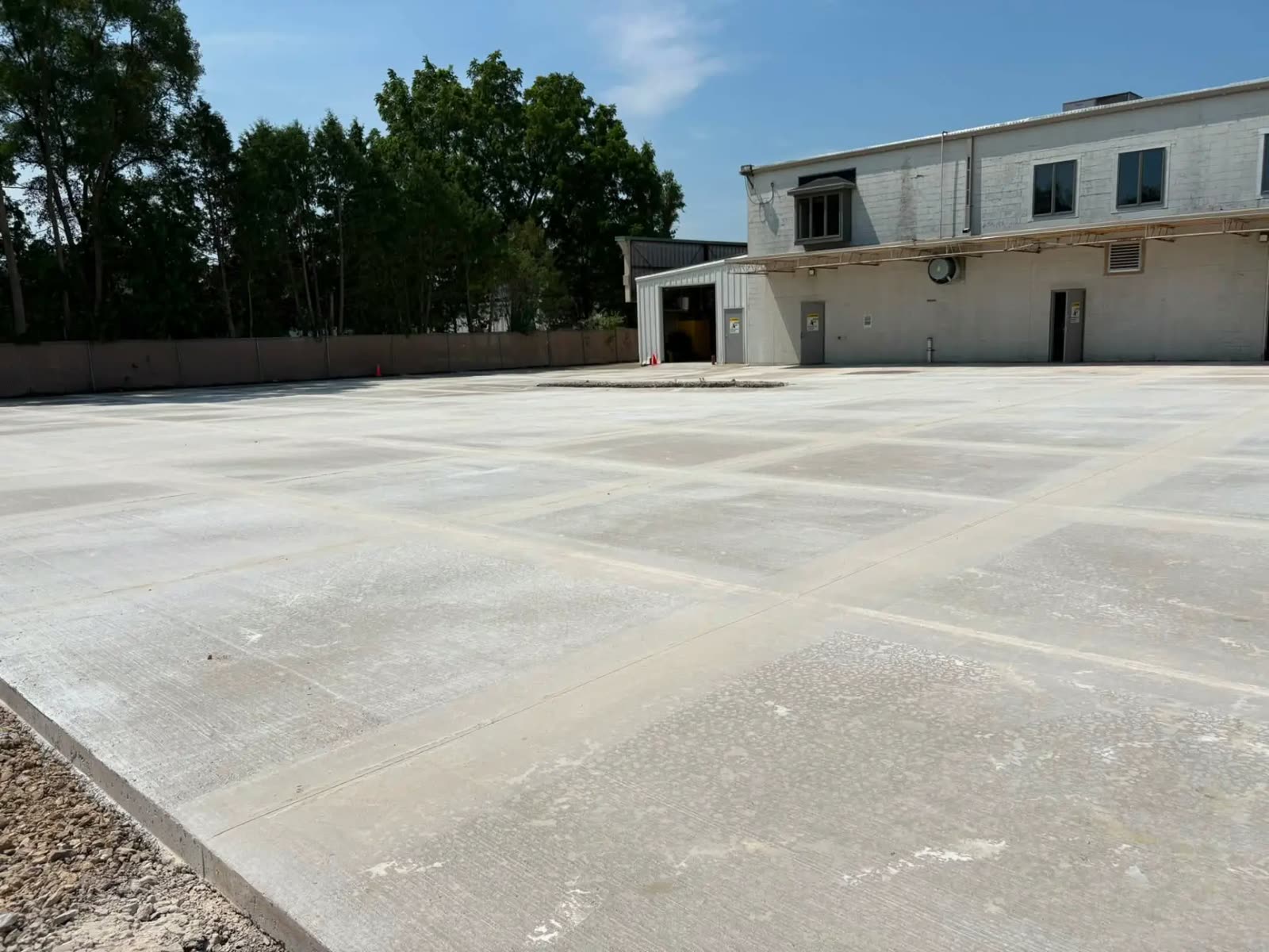 Large commercial concrete lot poured behind a warehouse
